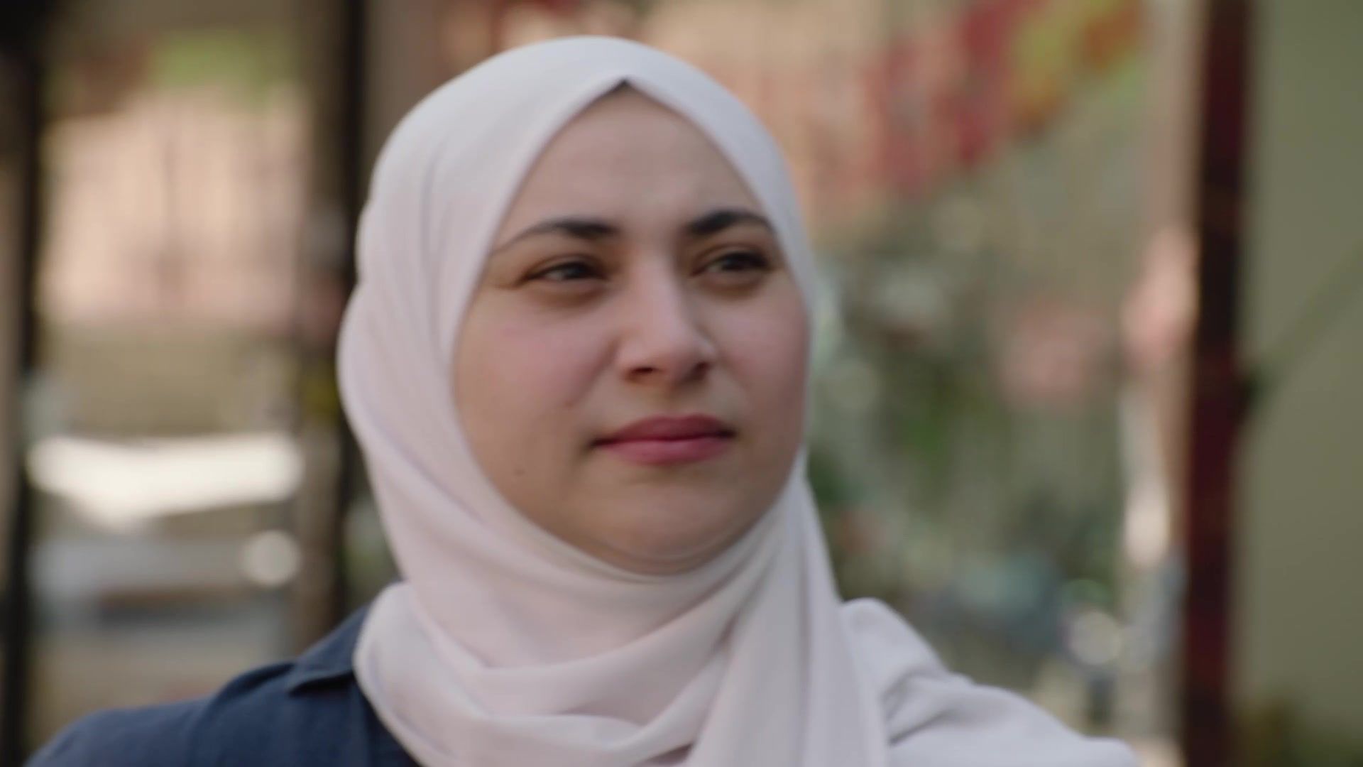 Aber Kawas outside a storefront in the walking-interview campaign video